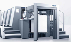 Obraz przedstawia maszyny drukarskie ustawione w hali produkcyjnej