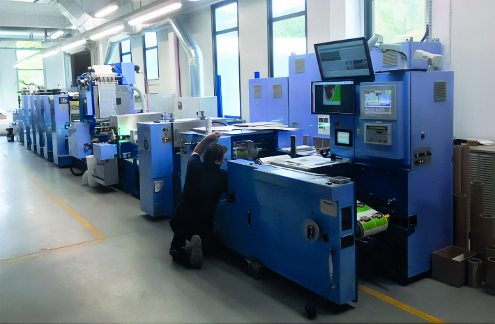 zdjęcie przedstawia mężczyzne stojącego przy maszynie drukarskiej